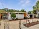 Mid-century home featuring a concrete fence, stucco walls, and orange trim, under blue skies at 2303 Bonneville Dr, Orlando, FL 32826