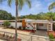 Mid-century home featuring a concrete fence, stucco walls, and orange trim with a convenient carport at 2303 Bonneville Dr, Orlando, FL 32826