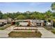 Mid-century home featuring a concrete fence, stucco walls, and orange trim, under blue skies at 2303 Bonneville Dr, Orlando, FL 32826