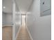 A long hallway with light gray walls and light wood-look flooring leads to a bedroom at 2303 Bonneville Dr, Orlando, FL 32826
