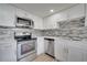 Updated kitchen with stainless steel appliances, stylish backsplash, and modern design at 2303 Bonneville Dr, Orlando, FL 32826