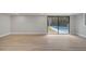 A living room with wood-look floors, gray walls, and a sliding door leading to the pool at 2303 Bonneville Dr, Orlando, FL 32826