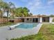 Backyard pool with diving board, ladder, and surrounding patio and lush landscaping is an oasis at 2303 Bonneville Dr, Orlando, FL 32826