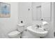 Clean and compact half-bathroom featuring white walls, toilet, and sink with mirror and cabinet at 2382 Zaballina Pl, Kissimmee, FL 34747