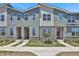 Exterior shot of modern townhouses with stone accents, contemporary design, and manicured landscaping at 2382 Zaballina Pl, Kissimmee, FL 34747