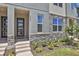 Exterior of a modern townhome featuring a stone facade, contemporary door, and well-manicured landscaping at 2382 Zaballina Pl, Kissimmee, FL 34747