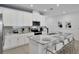Stylish kitchen featuring white cabinetry, stainless steel appliances, granite countertops, and island seating for four at 2382 Zaballina Pl, Kissimmee, FL 34747