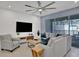 Bright living room features modern TV, plush sofa, accent chair, leading to an outdoor patio and pool at 2382 Zaballina Pl, Kissimmee, FL 34747