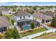 Aerial view of a two-story home with a screened pool, well-manicured lawn, and fenced backyard at 242 Milestone Dr, Haines City, FL 33844