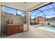 Covered outdoor kitchen with built-in bar, mini fridge, and access to the sparkling pool area at 242 Milestone Dr, Haines City, FL 33844