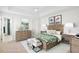 This staged bedroom features wood furnishings, neutral carpet and botanical wall art at 2460 Formax Dr, Orlando, FL 32828