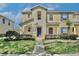 Charming two-story townhome featuring a blue front door, well-maintained landscaping, and a welcoming entrance at 2460 Formax Dr, Orlando, FL 32828