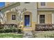 Up-close view of a charming blue front door adorned with a wreath and flanked by manicured landscaping at 2460 Formax Dr, Orlando, FL 32828