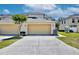 Attached two-car garage featuring a paved driveway and manicured landscaping at 2460 Formax Dr, Orlando, FL 32828