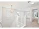 Bright loft features neutral carpet, a chandelier and white wood railing at 2460 Formax Dr, Orlando, FL 32828