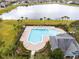 Aerial view of community pool with lounge chairs, lush greenery, and a serene lake backdrop at 2460 Formax Dr, Orlando, FL 32828