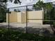 Community racquetball court featuring a concrete floor and tall, enclosed walls, surrounded by a chain-link fence at 2460 Formax Dr, Orlando, FL 32828