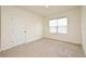 Empty bedroom with carpet, window, and door at 2524 Harmonia Hammock Rd, Harmony, FL 34773