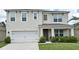 Charming two-story home features a two car garage, well-manicured lawn and lush shrubbery at 2524 Harmonia Hammock Rd, Harmony, FL 34773