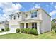 Beautiful two-story home with manicured lawn, and inviting front porch with stylish accents at 2524 Harmonia Hammock Rd, Harmony, FL 34773