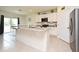 Bright kitchen with white cabinets, granite countertops, stainless steel appliances, and island overlooking breakfast area at 2524 Harmonia Hammock Rd, Harmony, FL 34773