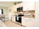 Stainless appliances and granite counters accent the white cabinets in this modern and bright kitchen at 2524 Harmonia Hammock Rd, Harmony, FL 34773