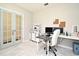 Well-lit home office with modern furniture, including white desk and blue french doors at 2524 Harmonia Hammock Rd, Harmony, FL 34773