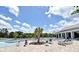 Community pool with lounge seating, palm trees, and clubhouse in the background at 2524 Harmonia Hammock Rd, Harmony, FL 34773