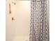 Walk-in shower with white tile, brushed silver fixtures, and a shower curtain at 2524 Harmonia Hammock Rd, Harmony, FL 34773