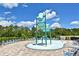 Community splash pad area with water features and lounge chairs around perimeter at 2524 Harmonia Hammock Rd, Harmony, FL 34773
