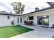 Backyard with a combination of artificial turf and concrete patio area, with outdoor dining at 2803 Tech Dr, Orlando, FL 32817