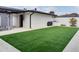 Backyard with artificial turf, patio area, and modern white brick exterior at 2803 Tech Dr, Orlando, FL 32817