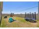 Fenced backyard features a playset, slide and trampoline on a sunny day at 292 Spirit Landings Cir, Winter Haven, FL 33880