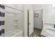 Bright bathroom with white tub/shower, wood-look floors, and door leading to vanity at 292 Spirit Landings Cir, Winter Haven, FL 33880