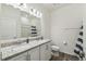 Bright bathroom with double vanity, granite countertop, modern lighting, and wood-look floors at 292 Spirit Landings Cir, Winter Haven, FL 33880