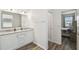 Bright bathroom featuring dual sinks, granite countertop and wood flooring, with a bedroom view at 292 Spirit Landings Cir, Winter Haven, FL 33880