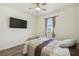 Relaxing bedroom featuring a ceiling fan, mounted television, comfortable bed, and natural light at 292 Spirit Landings Cir, Winter Haven, FL 33880