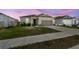 Inviting single-story home with a two-car garage and manicured lawn set against a twilight sky at 292 Spirit Landings Cir, Winter Haven, FL 33880