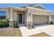 Welcoming home featuring a two-car garage, stone veneer accents, and well-kept front yard landscaping at 292 Spirit Landings Cir, Winter Haven, FL 33880