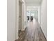 Hallway with wood-look flooring and white walls leading to a living room at 292 Spirit Landings Cir, Winter Haven, FL 33880