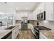 Contemporary kitchen with stainless steel appliances, granite countertops, and ample cabinet space with backyard view at 292 Spirit Landings Cir, Winter Haven, FL 33880