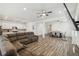 Spacious open-concept living room with wood floors, ceiling fans, and a large brown sectional sofa at 292 Spirit Landings Cir, Winter Haven, FL 33880