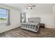 Cozy bedroom featuring a neutral color palette, hardwood flooring, and ample natural light from two windows at 292 Spirit Landings Cir, Winter Haven, FL 33880