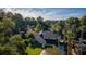 Landscaped exterior showing the dark roof, large yard and proximity to mature trees at 302 Hermits Trl, Altamonte Springs, FL 32701