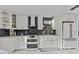 Modern kitchen features white cabinets, a farmhouse sink, and stainless steel appliances at 302 Hermits Trl, Altamonte Springs, FL 32701