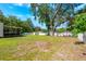 Expansive back yard featuring mature shade trees and a white vinyl privacy fence at 306 Albany Ave, Deland, FL 32724