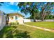The spacious back yard features healthy green grass, mature shade trees, and a white vinyl privacy fence at 306 Albany Ave, Deland, FL 32724