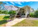 Charming backyard featuring a stone patio, grill, umbrella, and outdoor seating adjacent to the screened-in lanai at 306 Albany Ave, Deland, FL 32724