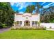 Charming stucco home with terra cotta roof details and a lush, landscaped front yard at 306 Albany Ave, Deland, FL 32724
