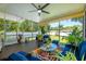 Inviting screened-in patio with ceiling fan, outdoor seating, and views of the lush backyard and surrounding landscaping at 306 Albany Ave, Deland, FL 32724